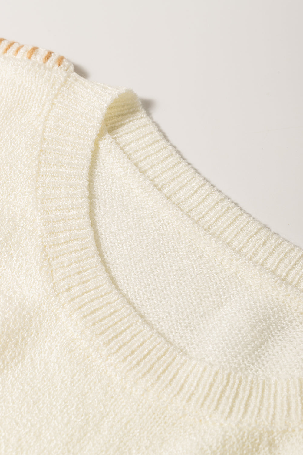 Bež pulover z razkritimi šivi in ​​spuščenimi ramenskimi žepi