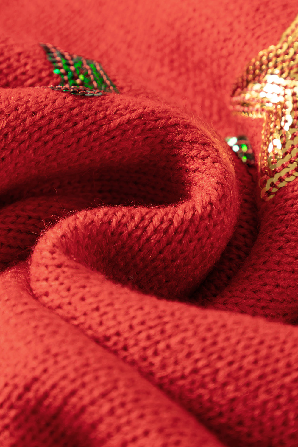 Vatrenocrveni pulover s skicom božićnog drvca sa šljokicama na spuštena ramena