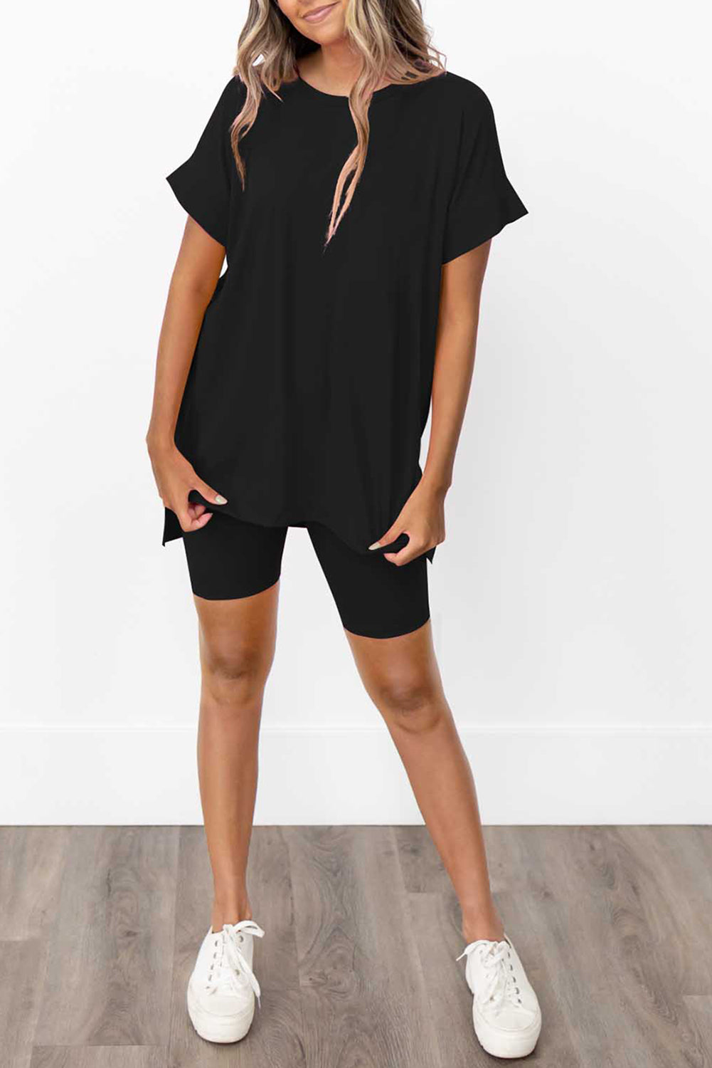 Schwarzes Set mit einfarbigem Tunika-T-Shirt und engen Shorts mit geteiltem Saum