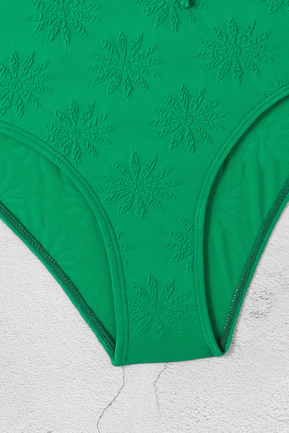 Svijetlo zeleni jednodijelni kupaći kostim s dubokim izrezom s volanima