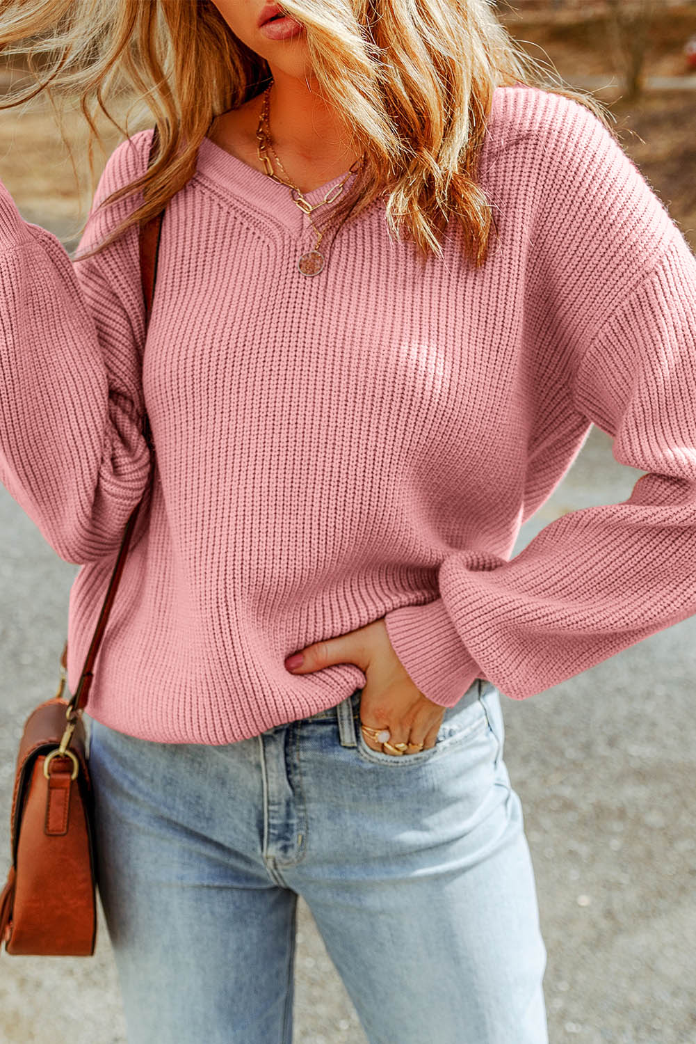 Rožnat pleten pulover z v-izrezom in spuščenimi rameni