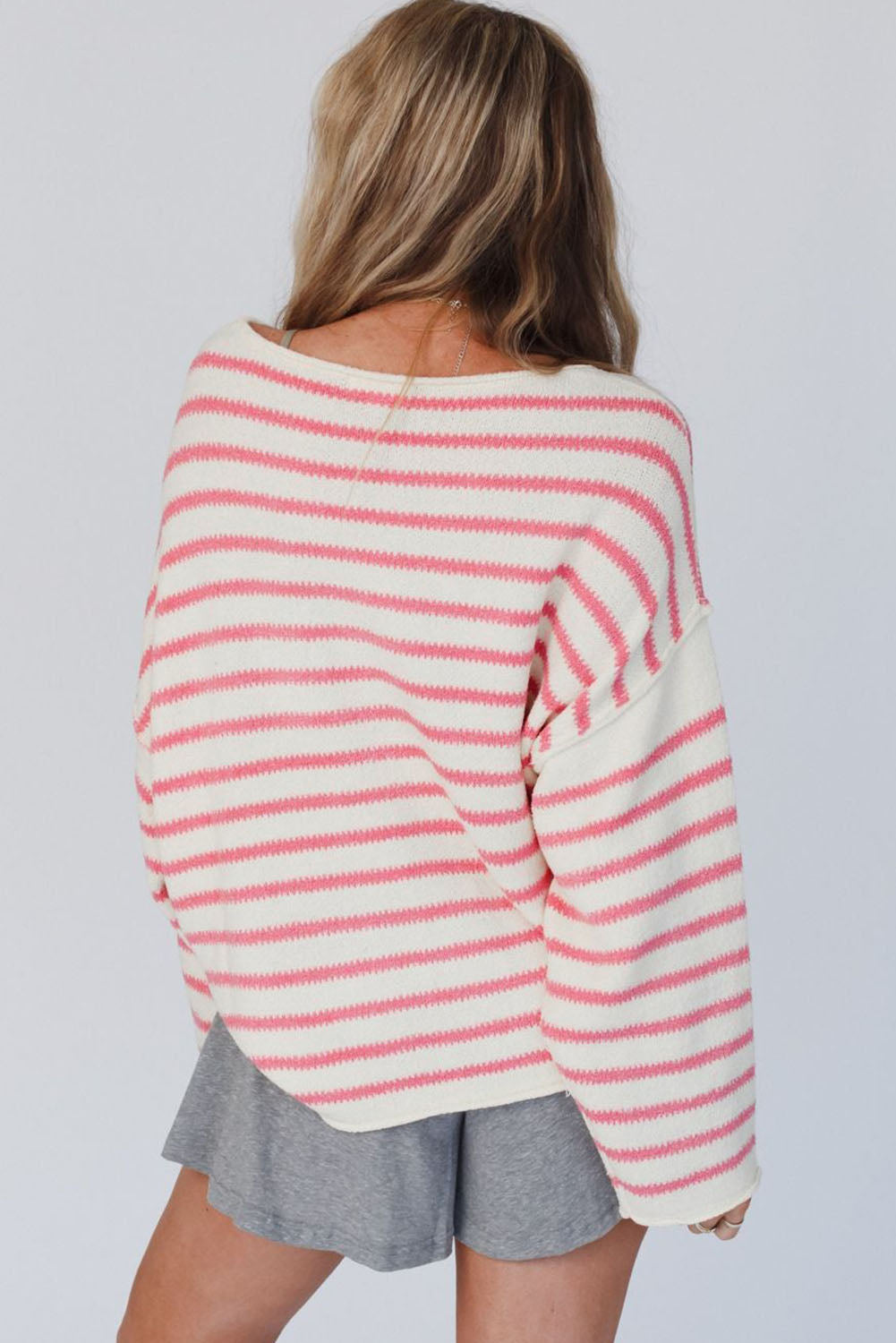 Prevelik pulover z rožnatimi črtami na spuščena ramena