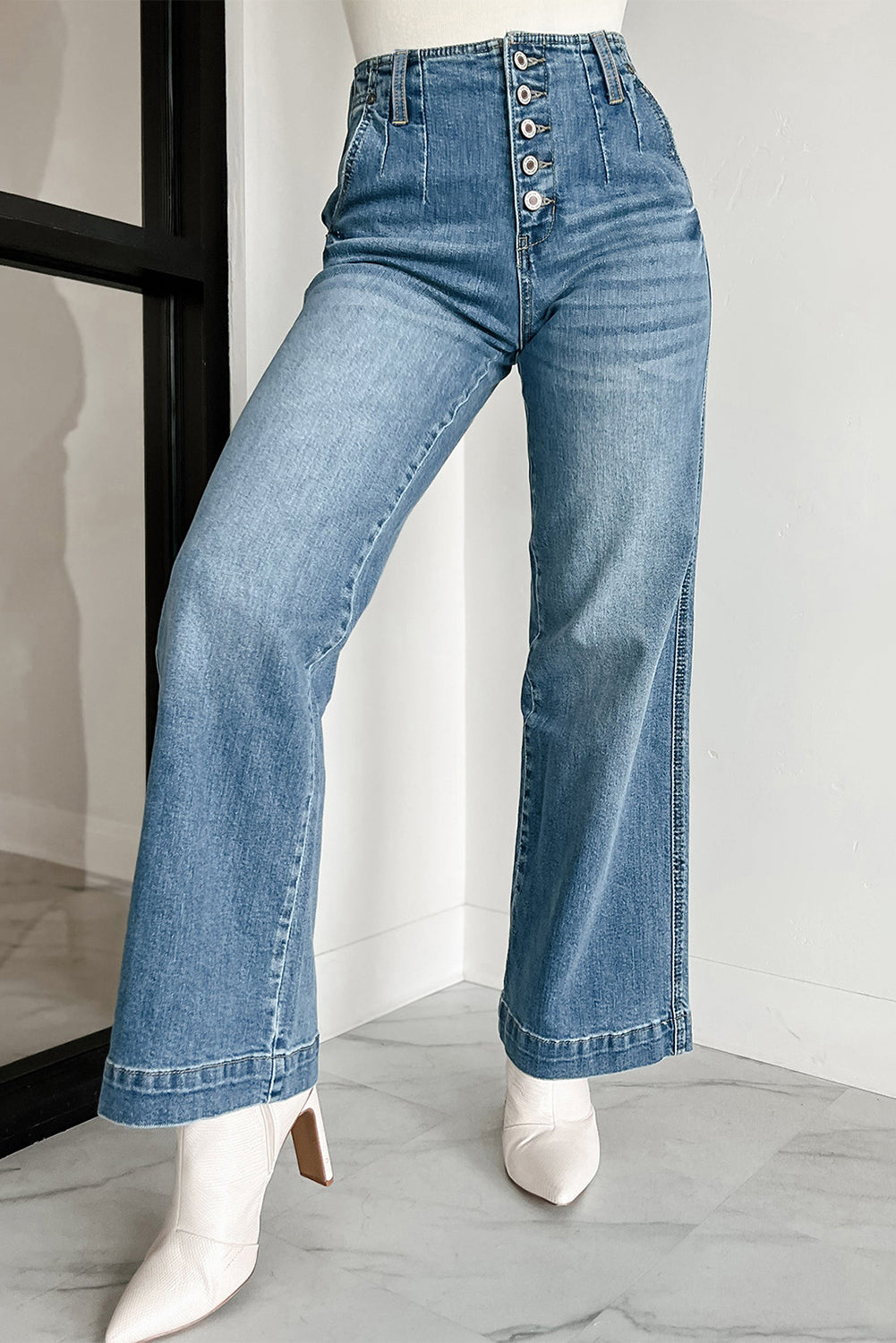 Dunkelblaue Jeans mit mehreren Knöpfen in mittlerer Waschung und geradem, lockerem Bein