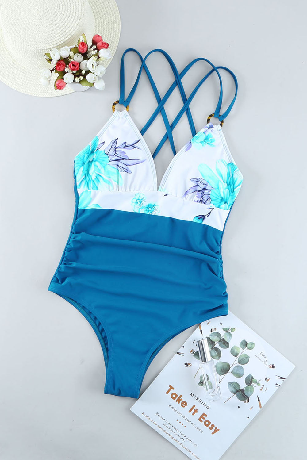 Nebeskoplavi jednodijelni kupaći kostim s ukrštenim leđima s cvjetnim blokovima