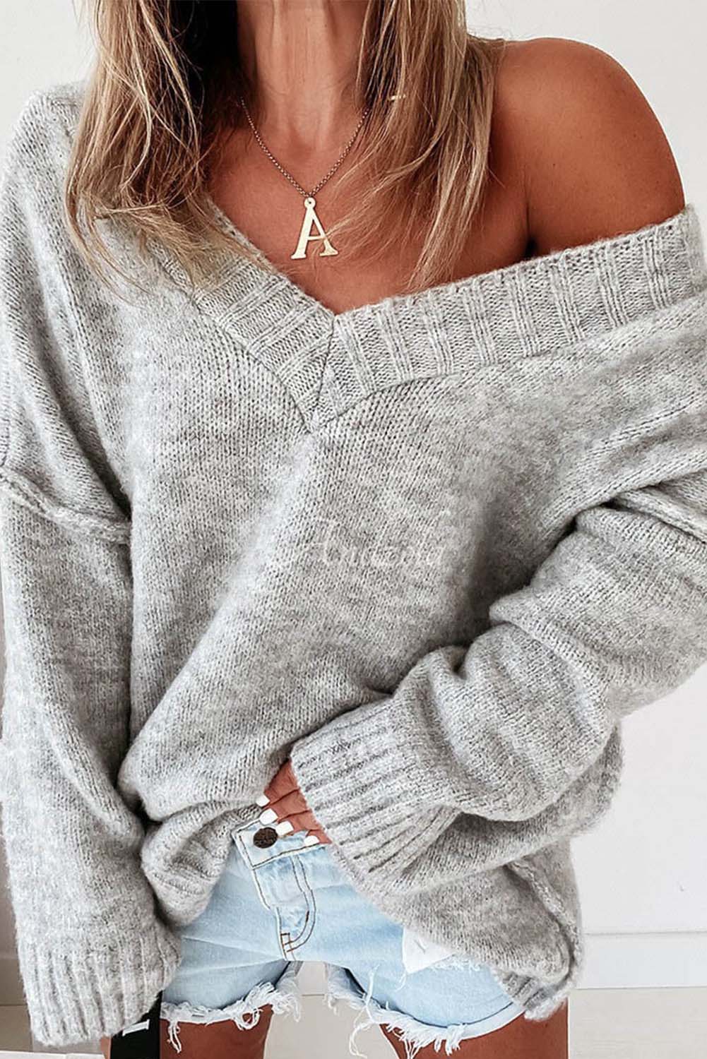 Rožnat pulover z razkritim šivom v izrezu