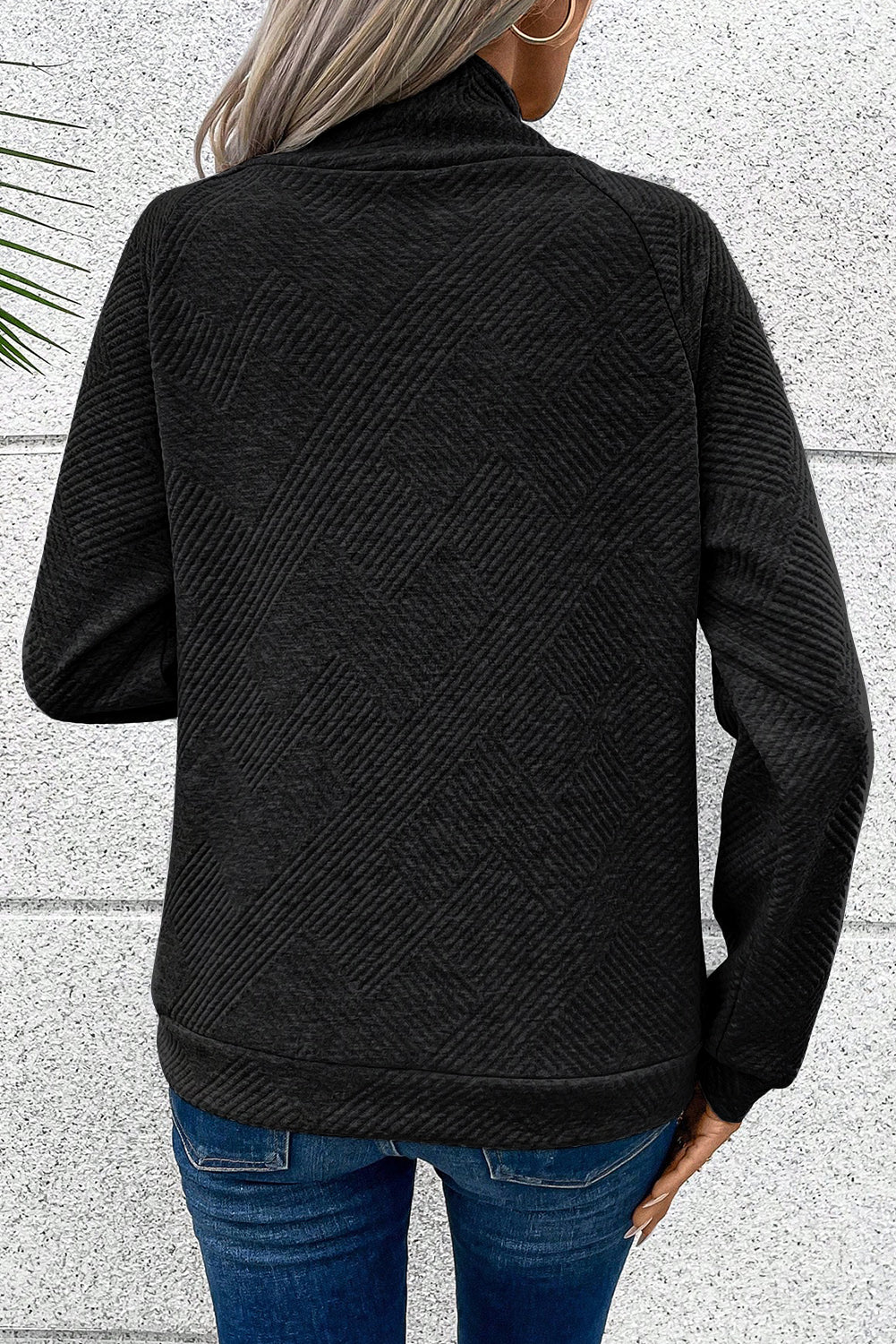 Črn pulover z asimetričnimi gumbi in visokim ovratnikom