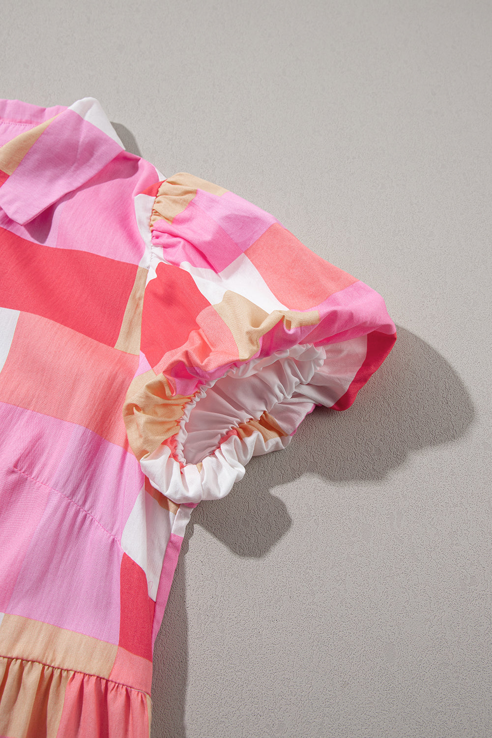 Rožnata večplastna obleka s karirastim potiskom in napihnjenimi rokavi