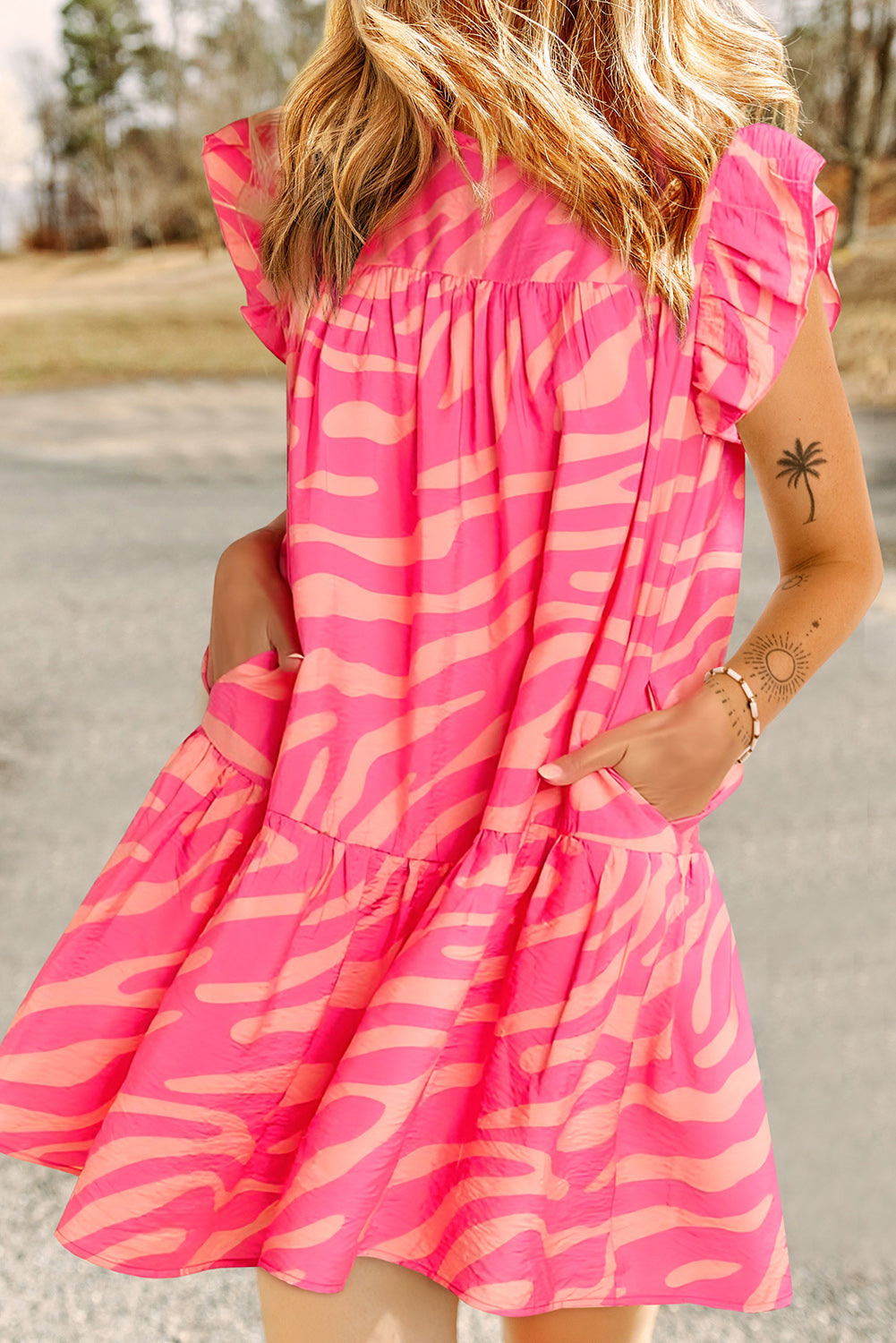 Ružičasta haljina s džepovima s otisnutim volanima i zebrastim prugama