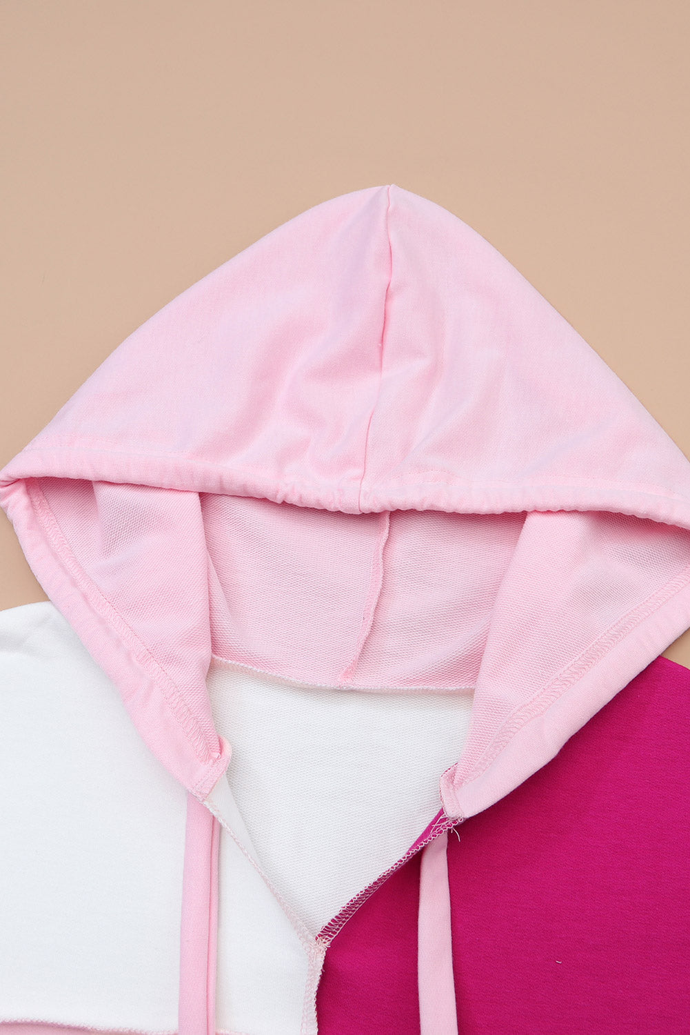 Pulover s kapuco z razkritimi šivi in ​​ohlapnimi rokavi v roza barvah