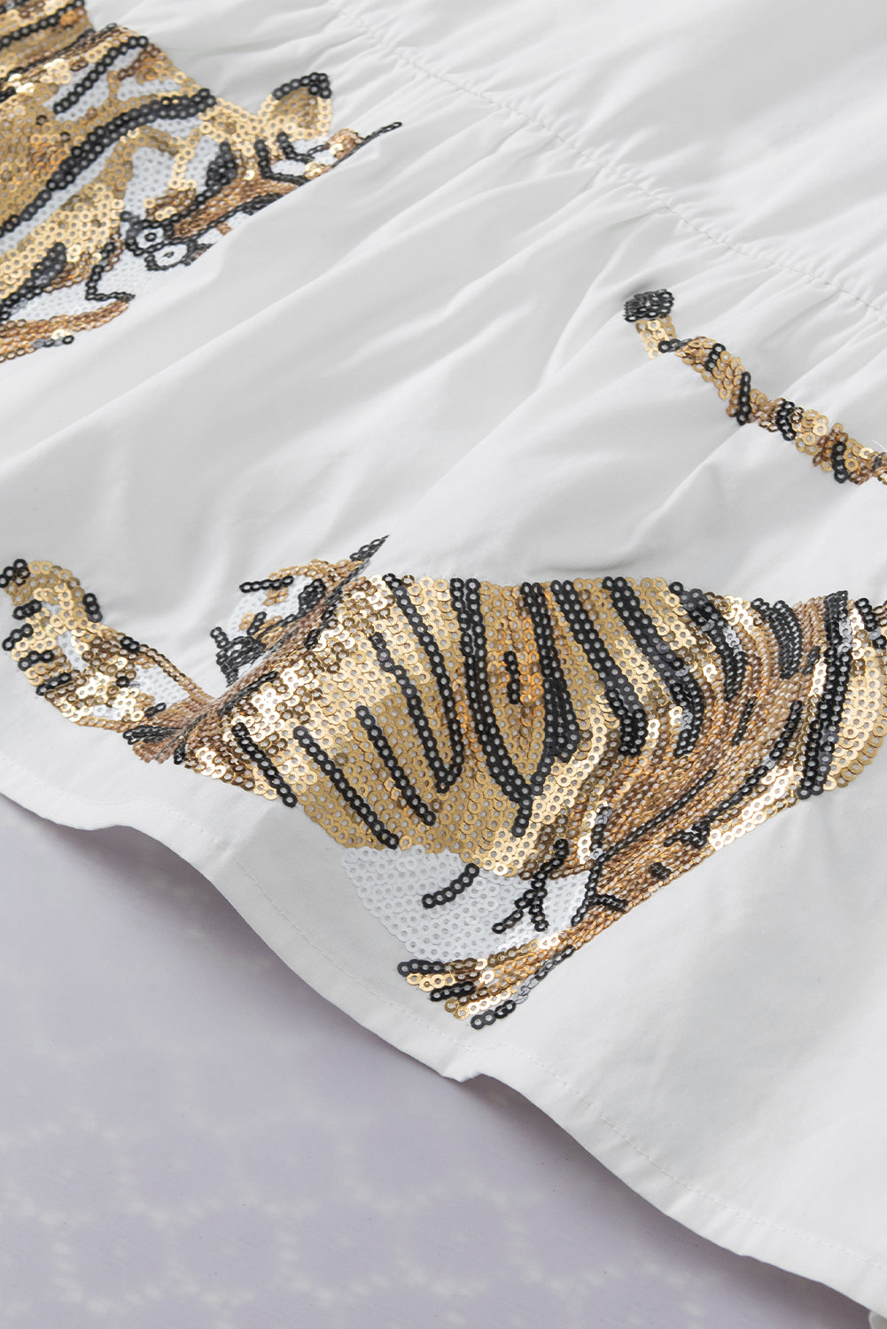 Bela tigrasta bluza z v-izrezom in napihnjenimi rokavi z bleščicami