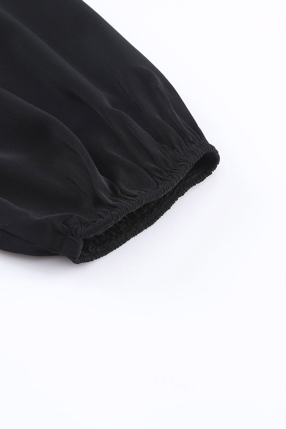 Črna vozlasta asimetrična bluza z odprtimi rameni