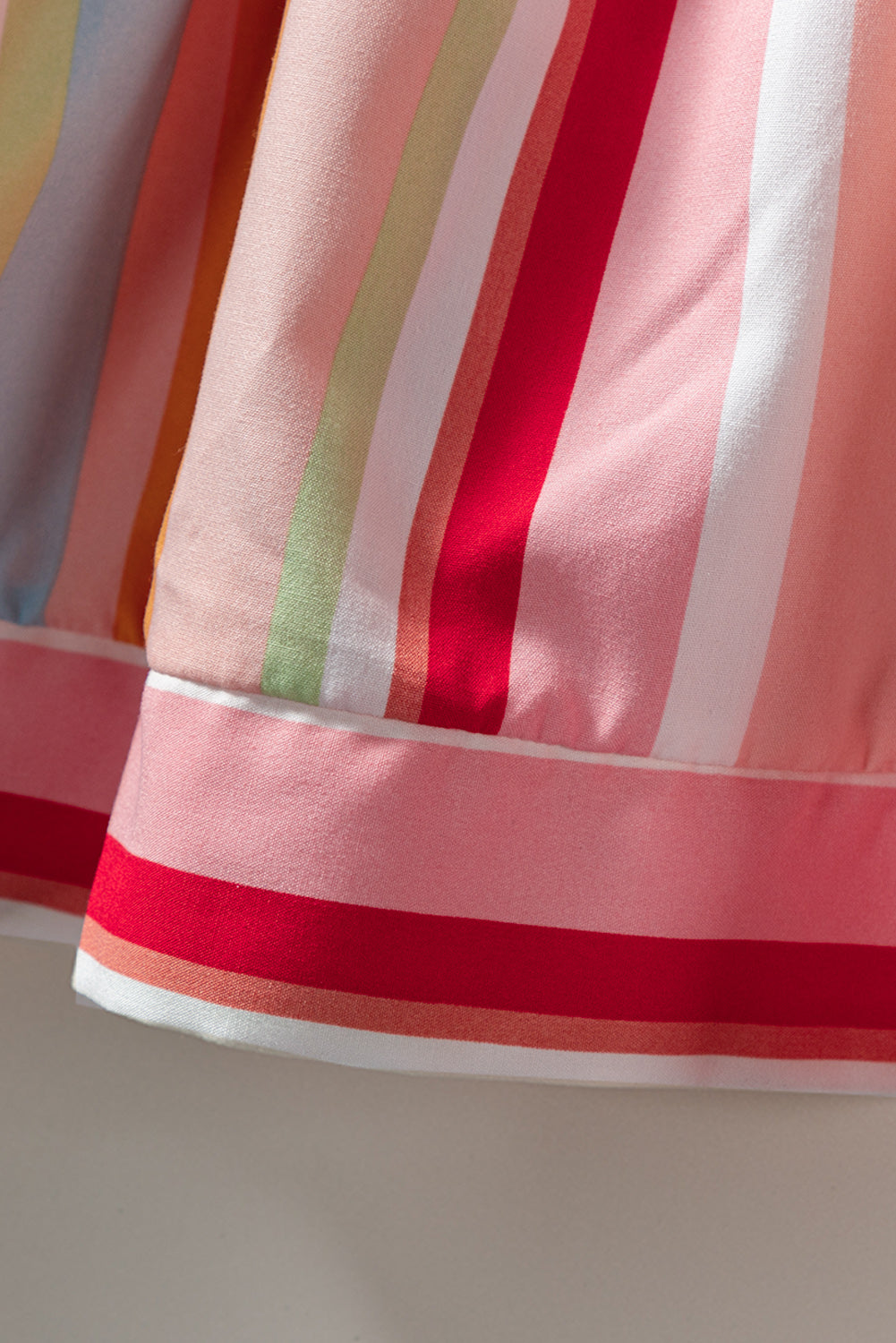 Rožnata večplastna obleka z naborki in mavričnimi črtami