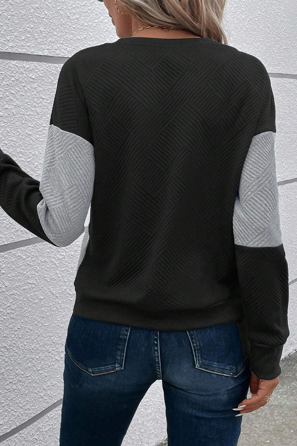Schwarzes, strukturiertes Oberteil mit überschnittener Schulterpartie im Farbblockdesign