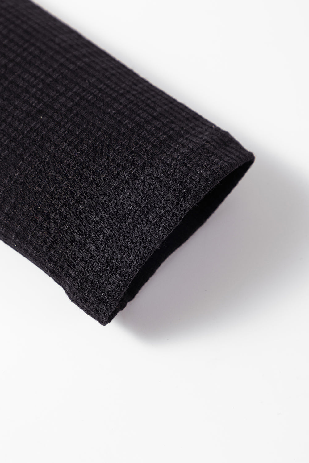 Črna rebrasta majica z dolgimi rokavi in ​​pletenimi gumbi