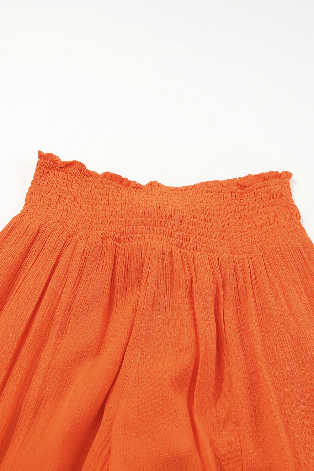 Orangefarbene Hose mit gesmokter Taille und weitem Bein
