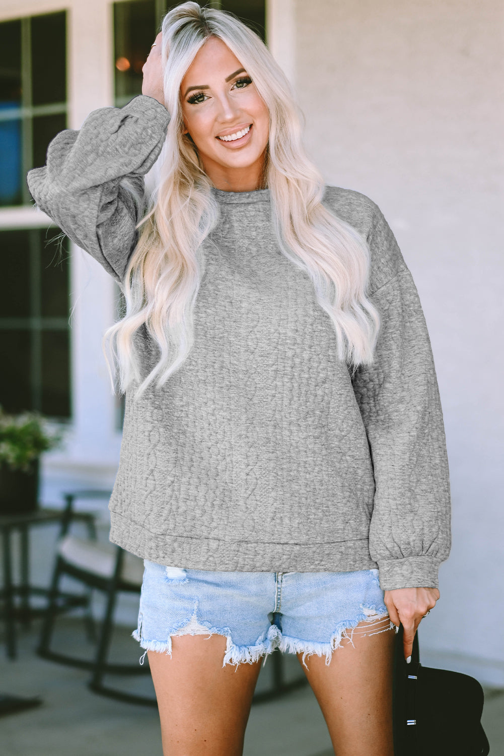 Siv pulover s kabelsko teksturo in spuščenimi rameni