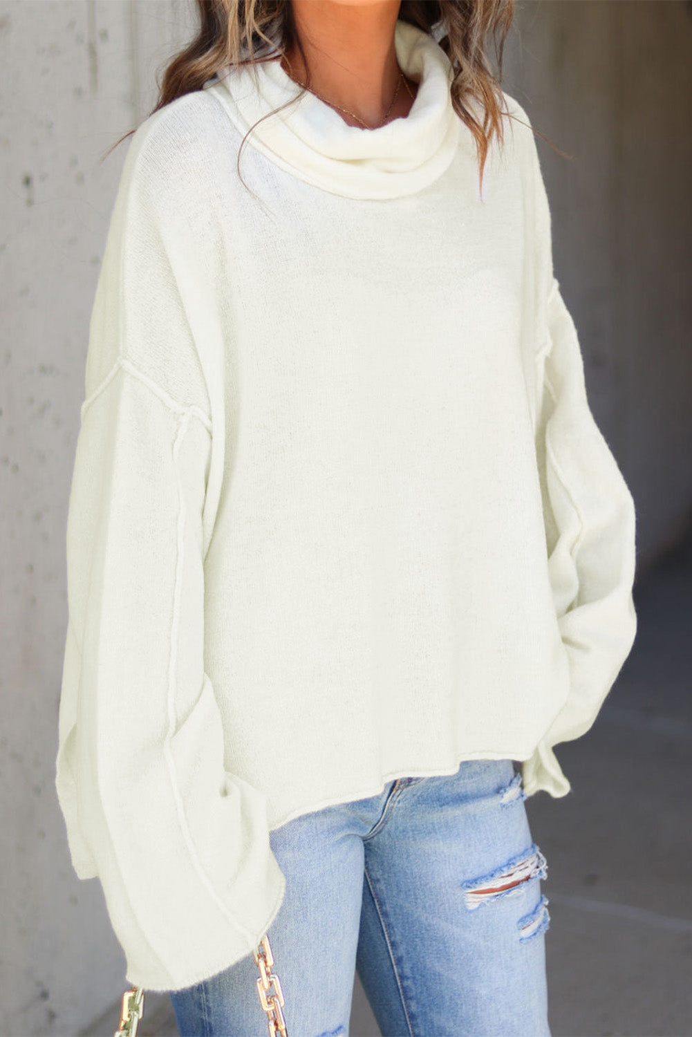 Prevelik pulover s stranskim razporkom v beli barvi z želvastim ovratnikom