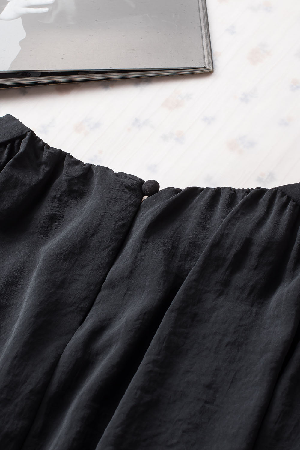 Črna podložena ohlapna bluza z manšetami in naborki na ramenih