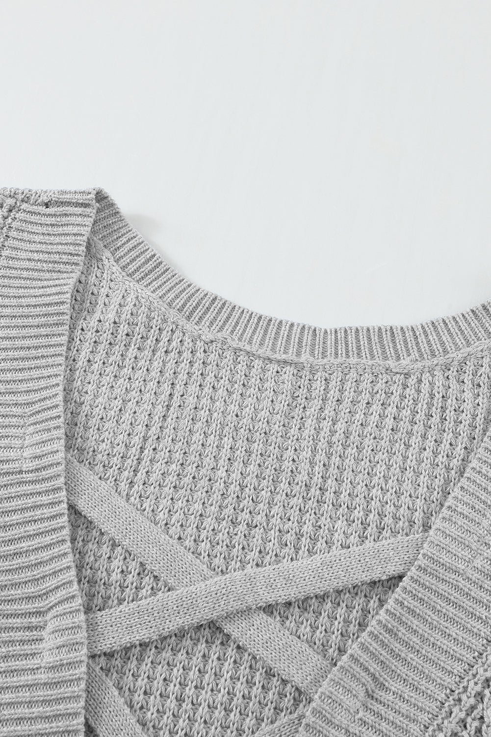 Grauer, ausgehöhlter Pullover mit Kreuzrücken