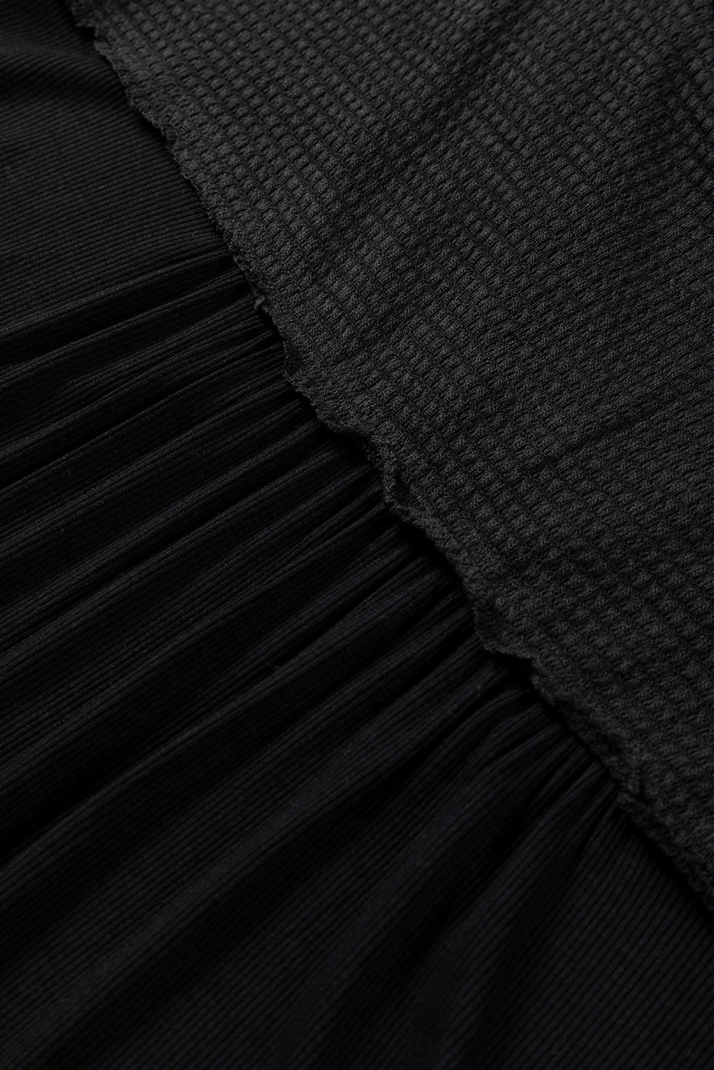 Camicetta borchiata con scollo a V e cuciture in maglia nera a contrasto