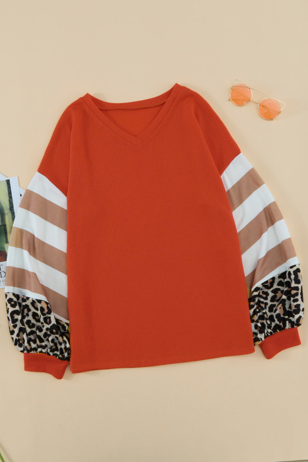 Orangefarbenes Oberteil mit V-Ausschnitt und Leopardenstreifen und Spleißlaternenärmeln