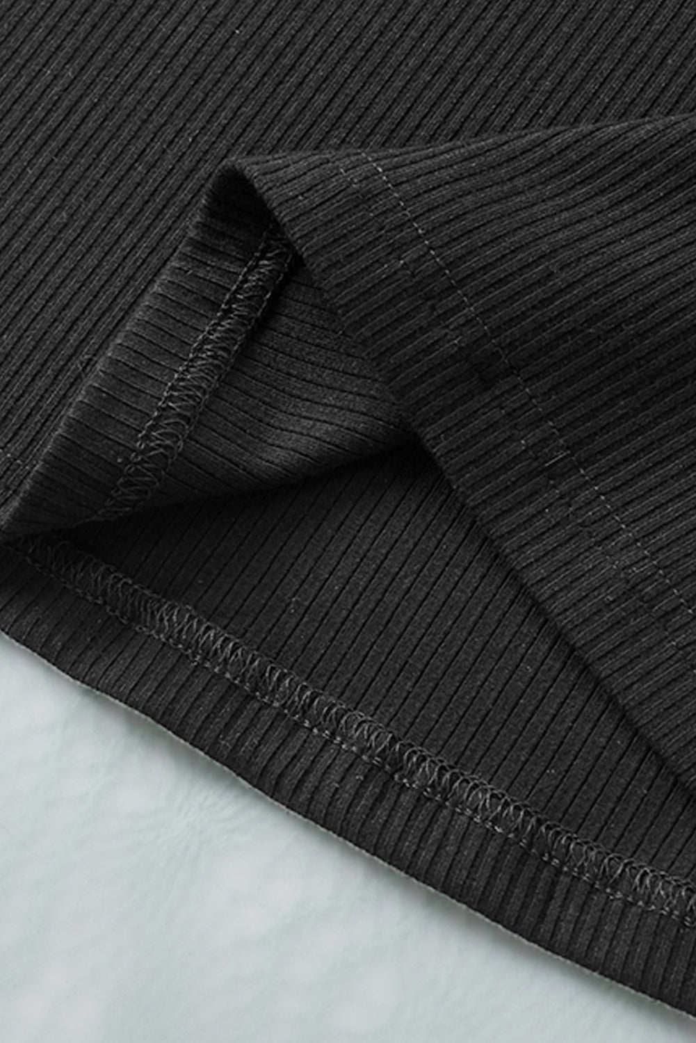 Črna pletena majica z nazobčanimi rokavi in ​​ušesci
