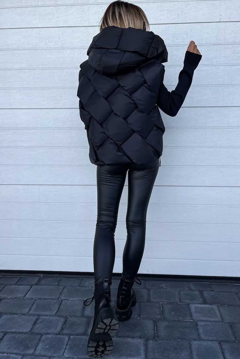 Manteau noir matelassé à capuche et fermeture éclair sur le devant