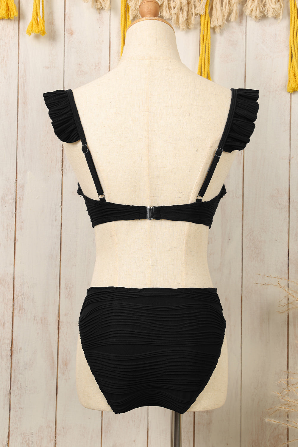 Črne bikini kopalke z valovito teksturo in nabranimi naramnicami