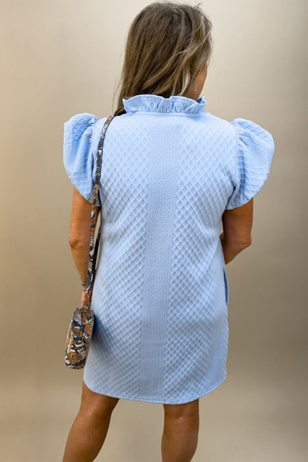 Svetlo modra teksturirana mini obleka z napihnjenimi rokavi in ​​naborkimi v-izrezom