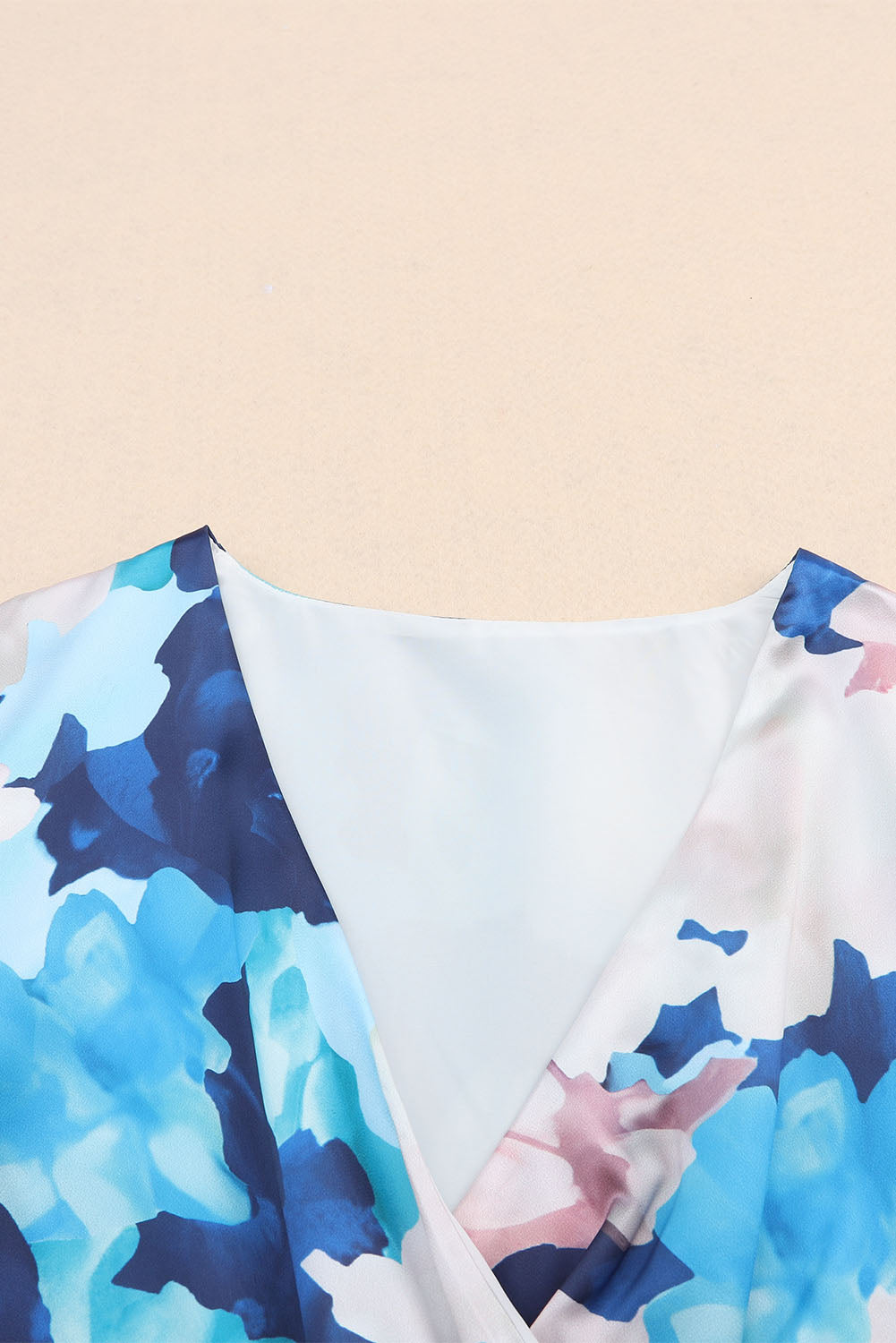 Robe bleue à volants nouée à manches longues et motif floral abstrait