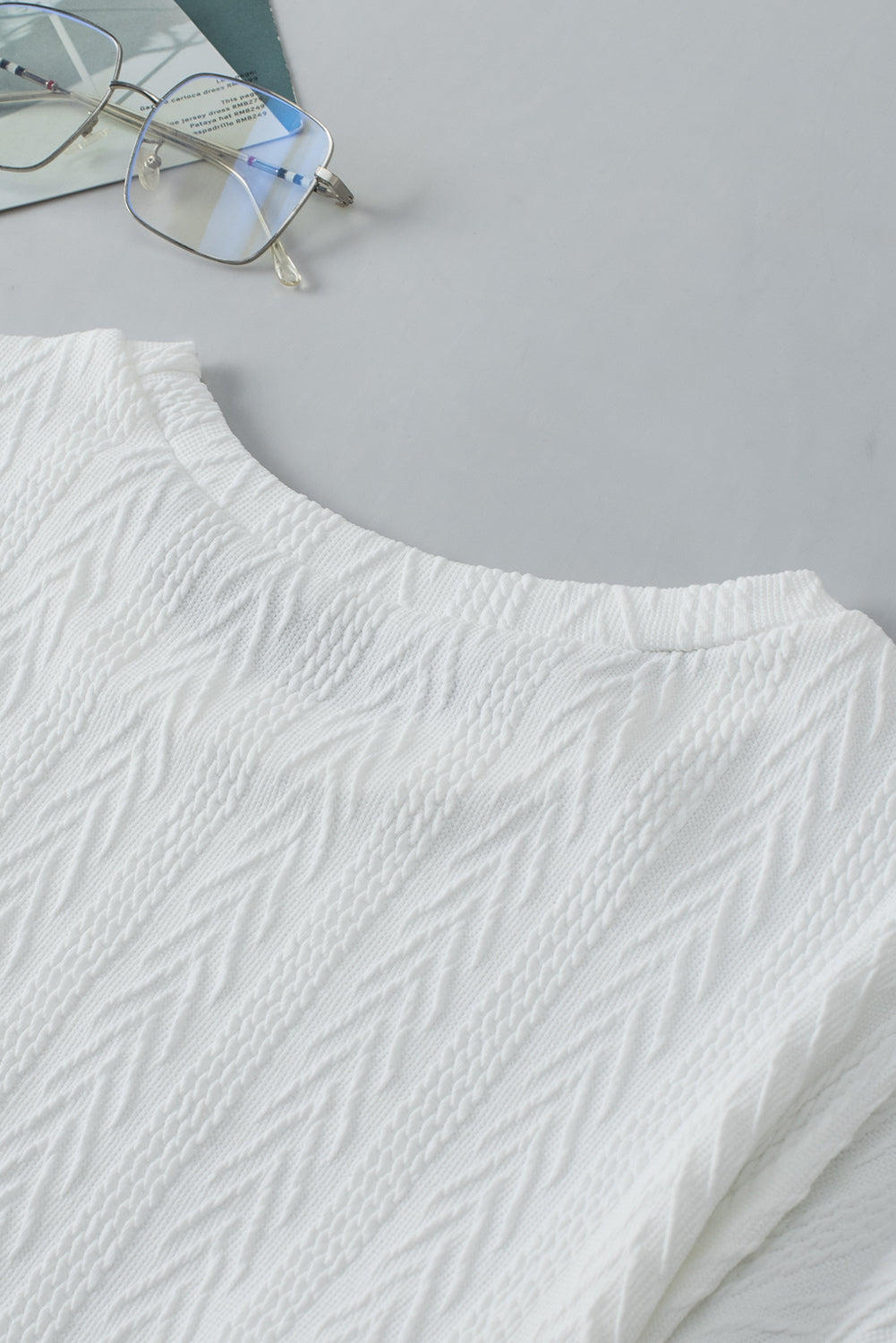 Bijela pletena majica s okruglim izrezom i spuštenim ramenima