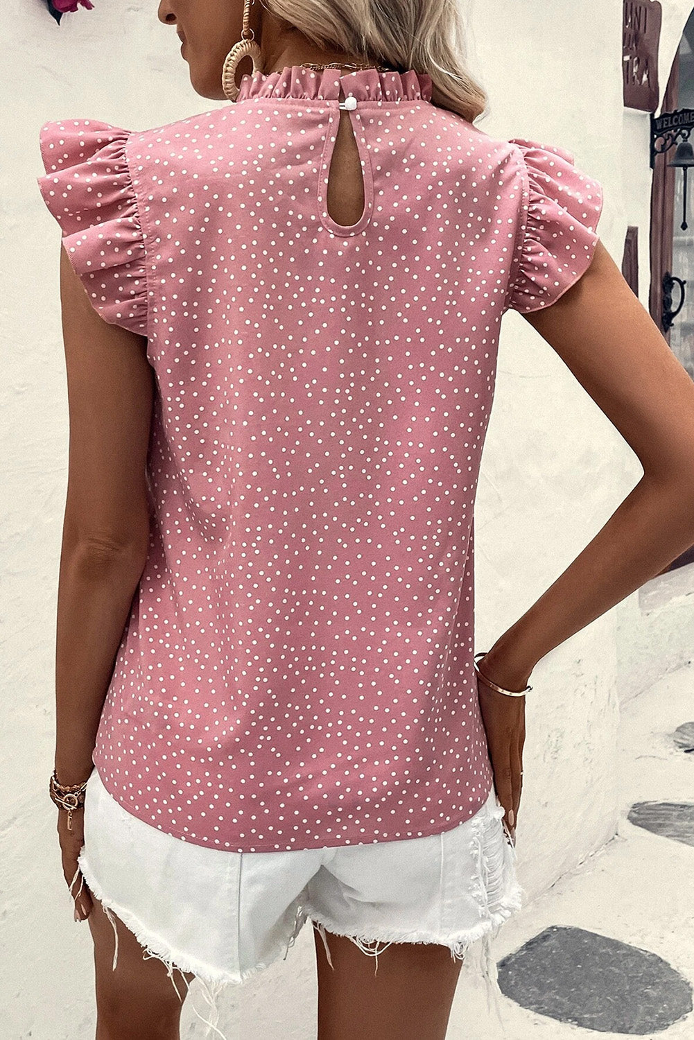 Ružičasta bluza na točkice s volanima i lepršavim rukavima oko vrata