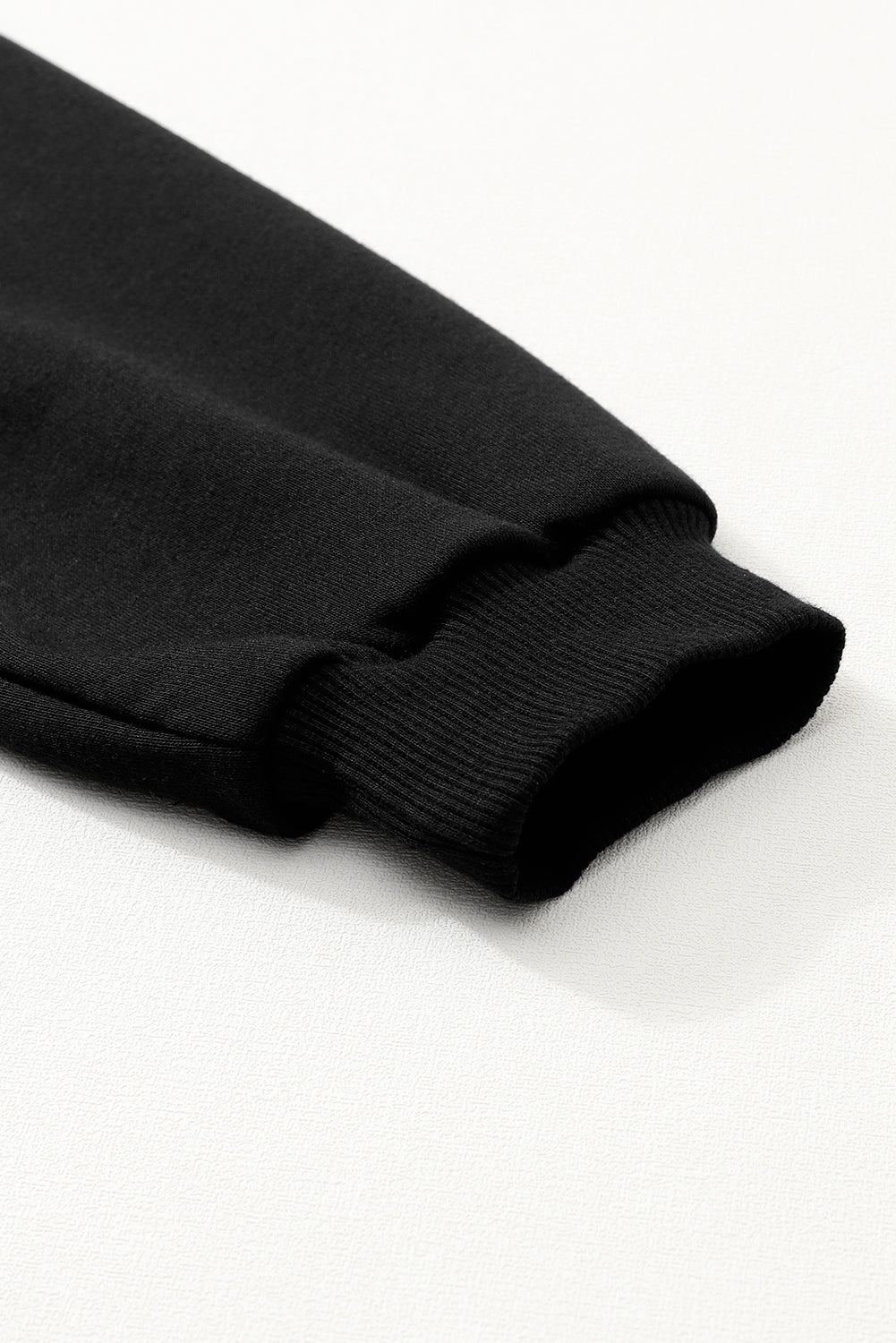 Mini-robe noire à manches bouffantes et ourlet à volants de couleur unie