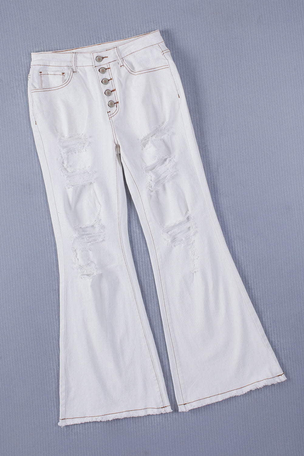 Bijele, svijetlo isprane traperice s lepršavim letvicama s prorezima i gumbima