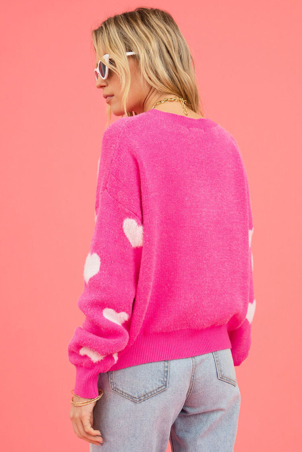 Leuchtend rosa flauschiger Pullover mit Valentinsherzen und überschnittener Schulter