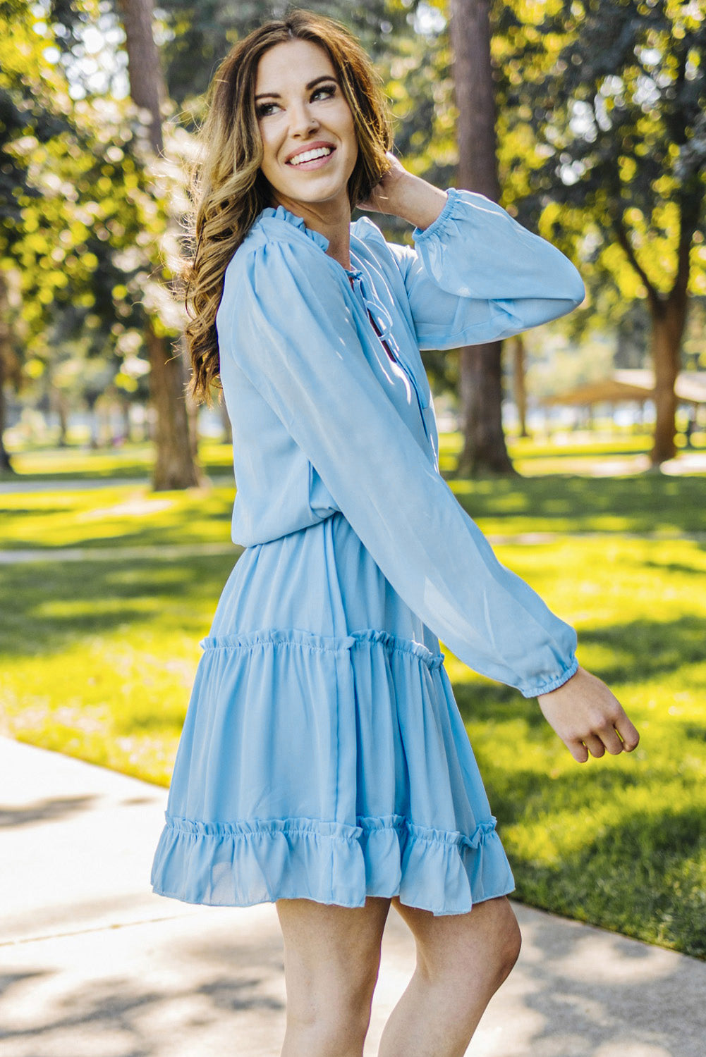 Mini-robe bleu clair à col en V et manches longues à volants et volants