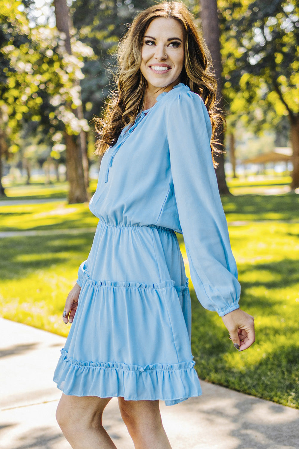 Mini-robe bleu clair à col en V et manches longues à volants et volants