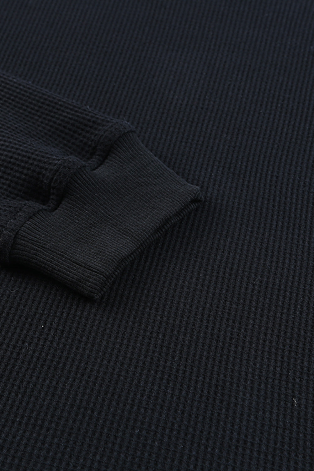 Črna pletena majica z okroglim izrezom in obrobo iz vaflja