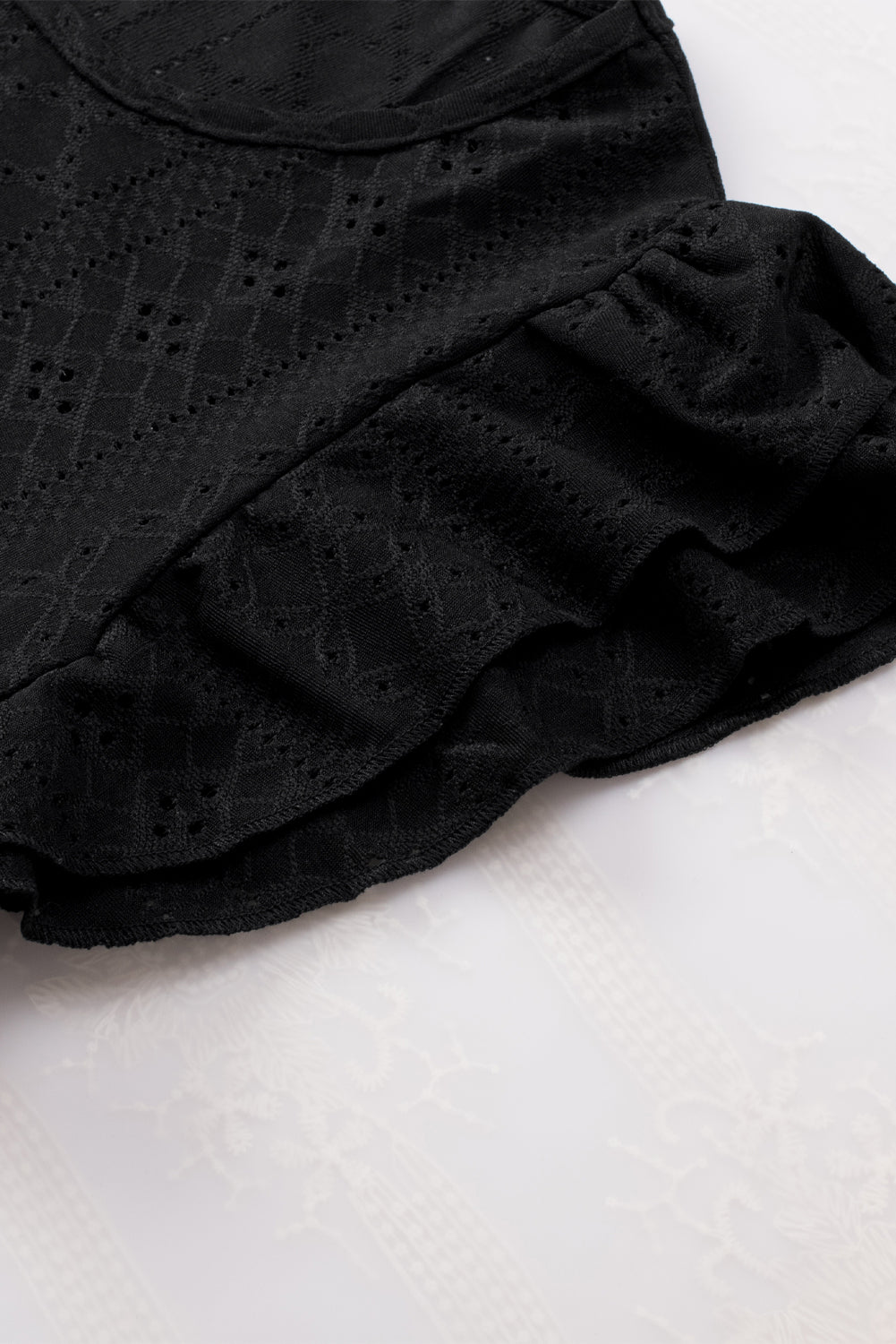 Blouse noire à manches courtes et volants texturés en losange