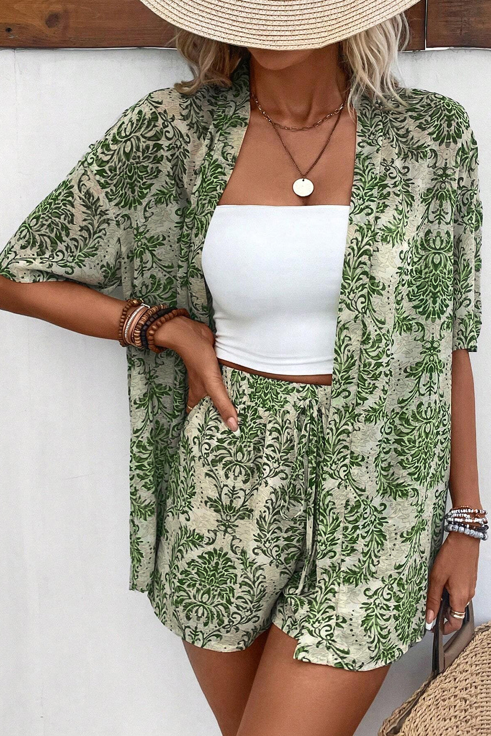 Grünes Vintage-Outfit mit Blumenmuster, offenem Oberteil und Shorts