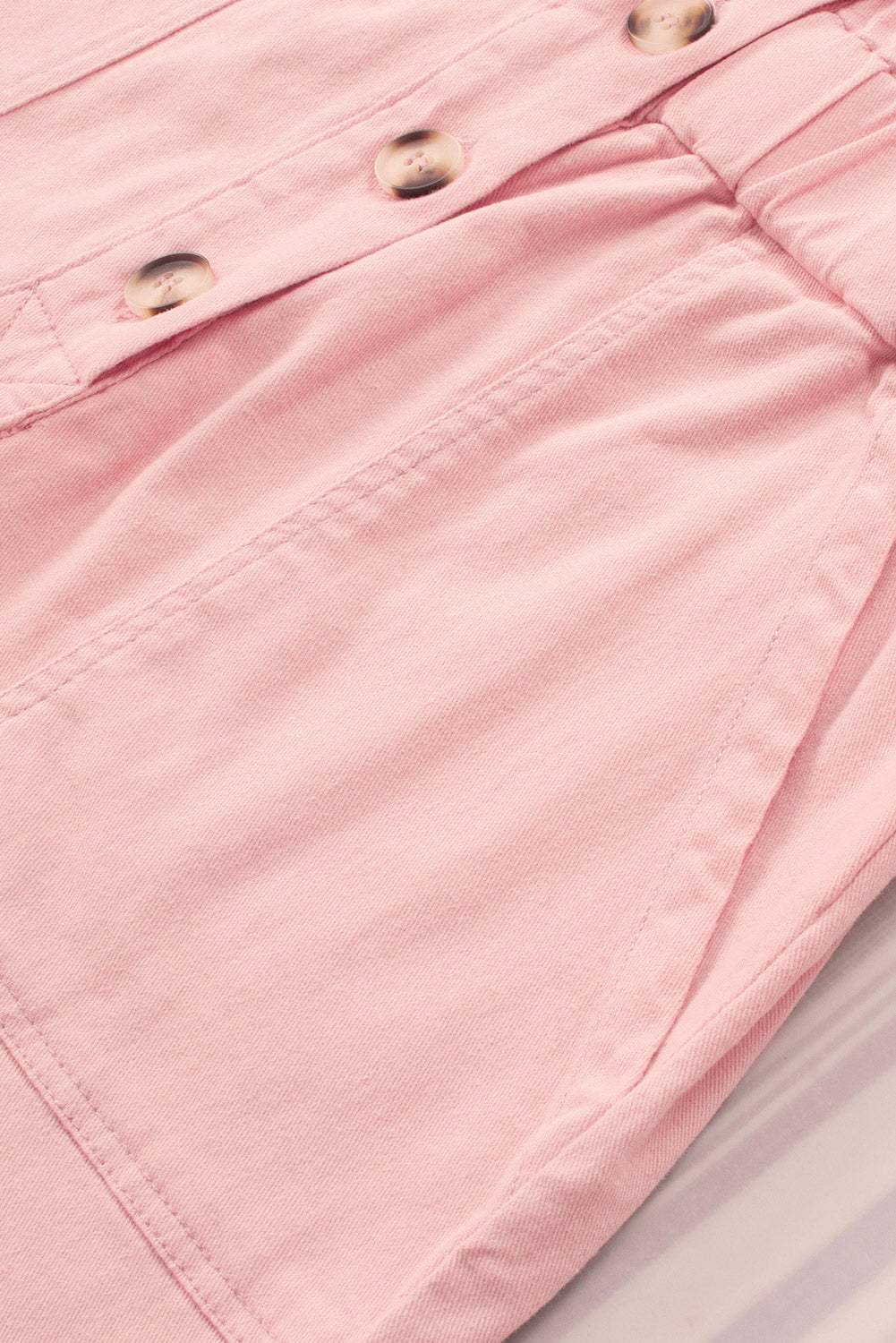 Barboteuse boutonnée en jean rose avec poches