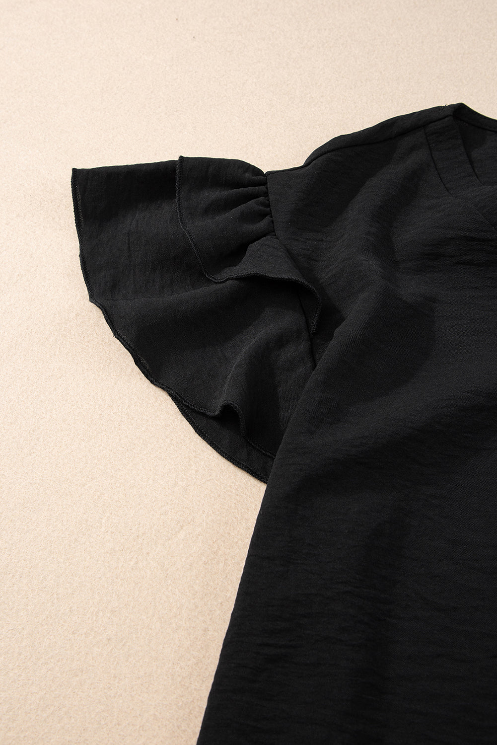 Črna bluza s kratkimi rokavi in ​​naborki v izrezu