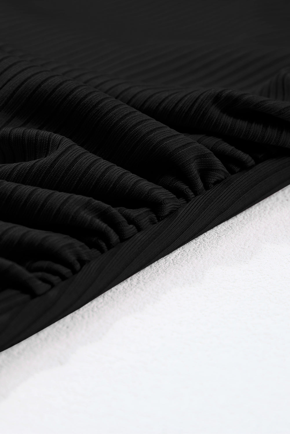 Črne enodelne kopalke z rebrasto teksturo in okroglim izrezom