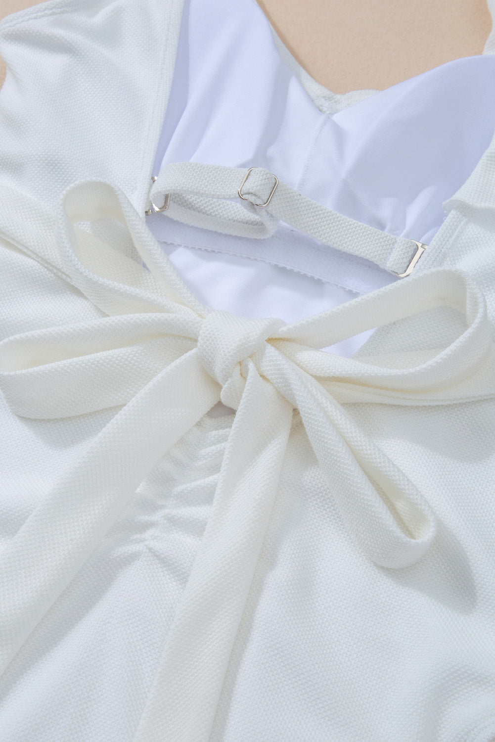 Costume da bagno intero bianco asimmetrico con volant e laccetto in vita