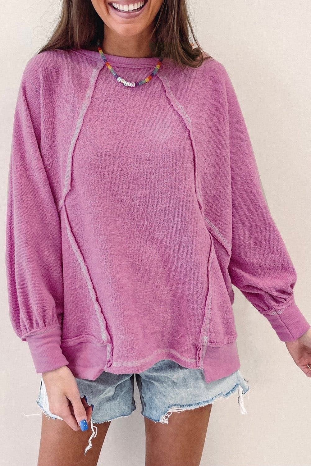 Ružičasti pulover od frotira s otkrivenim šavovima s okruglim izrezom