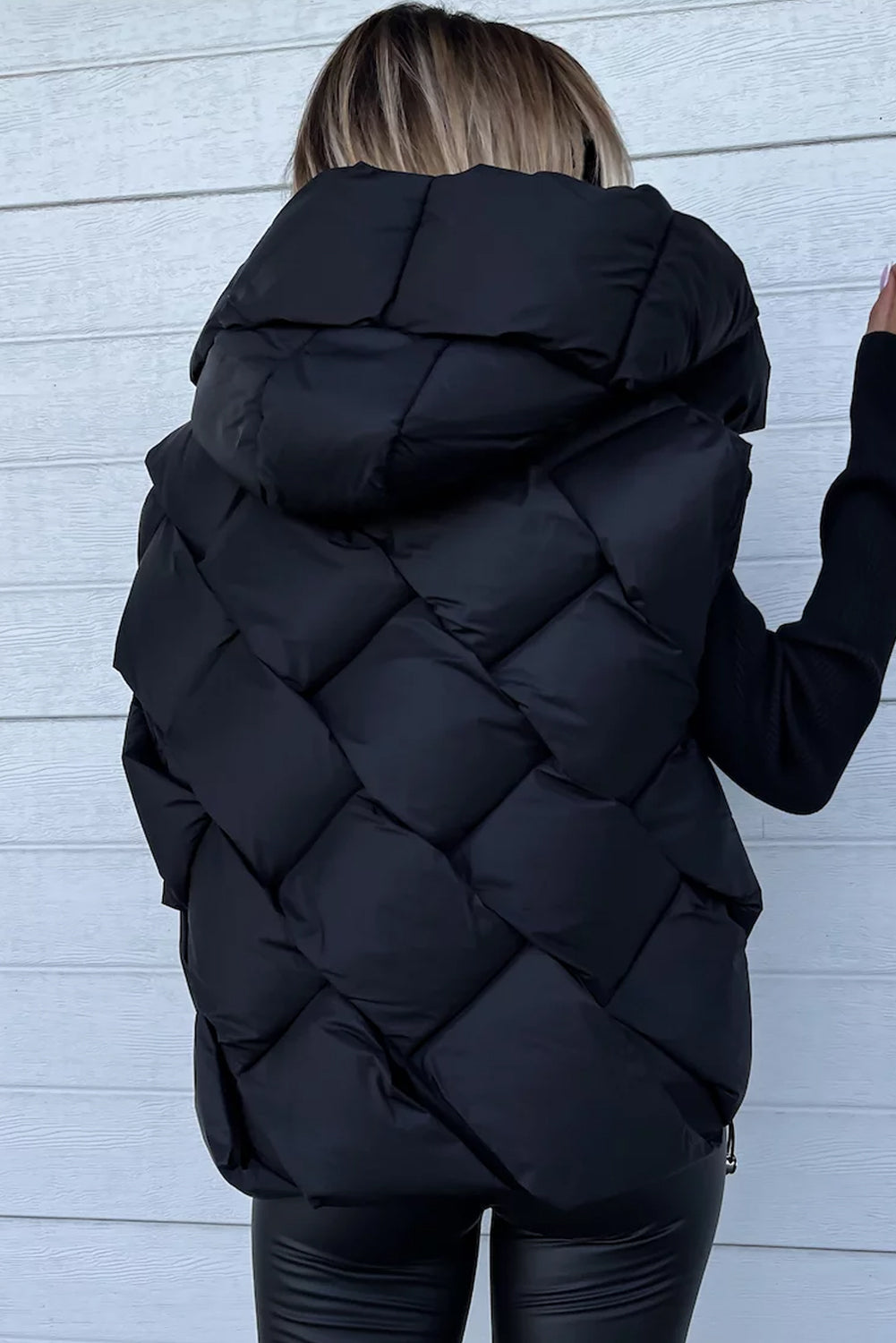 Manteau noir matelassé à capuche et fermeture éclair sur le devant