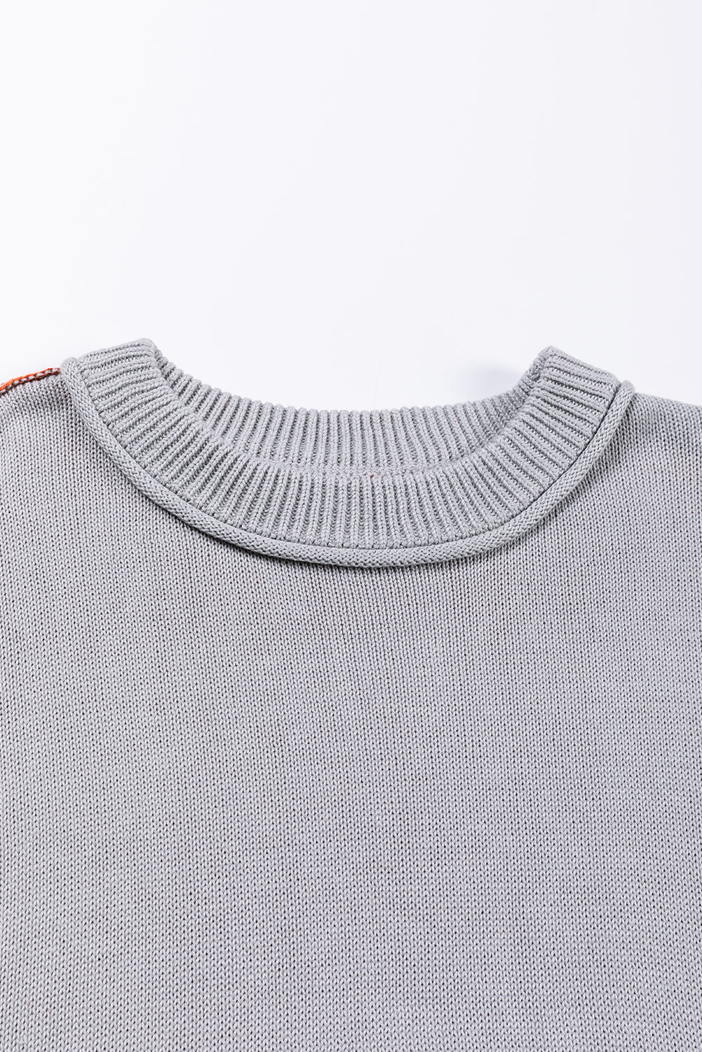 Siv pulover z rebrastimi rokavi in ​​barvnimi bloki