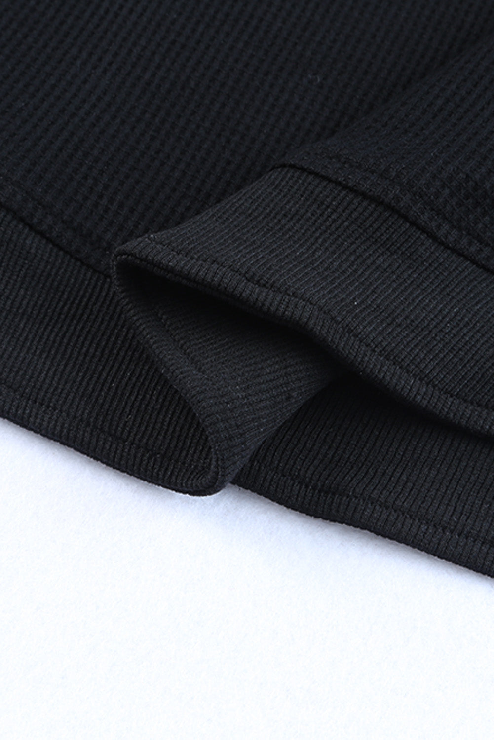 Haut noir en tricot gaufré à bordure côtelée et col rond