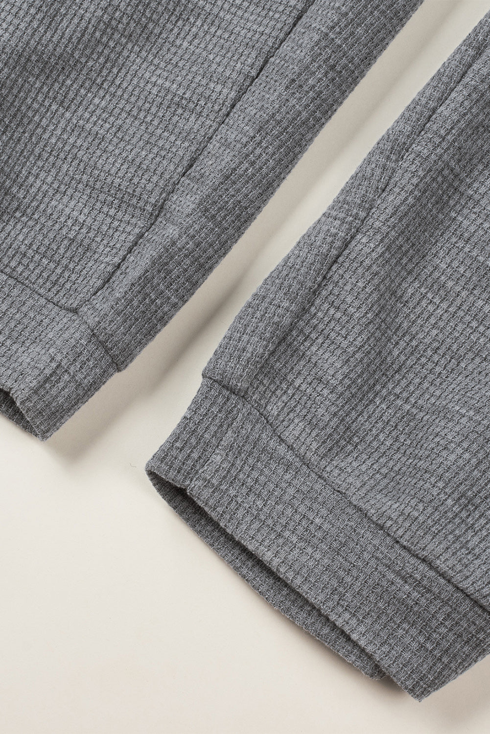 Siv teksturiran kombinezon brez rokavov z žepi in v-izrezom