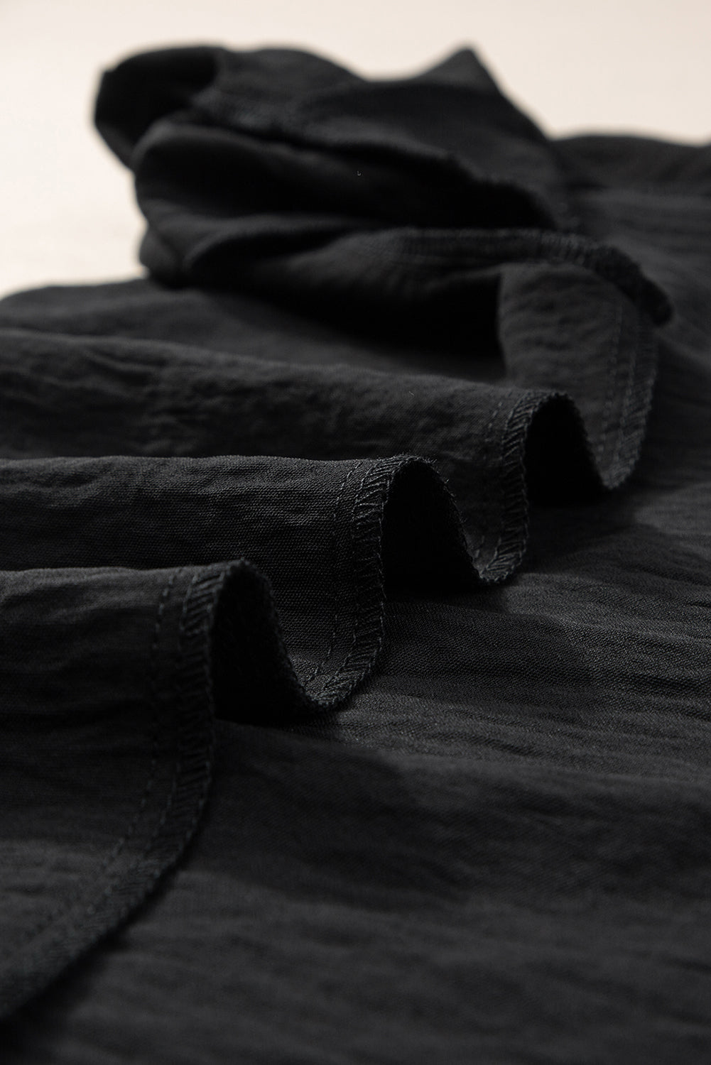 Črna bluza s kratkimi rokavi in ​​naborki v izrezu